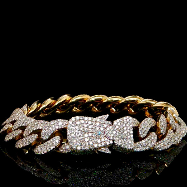 Gold chain bracelet with diamond accents on a black background