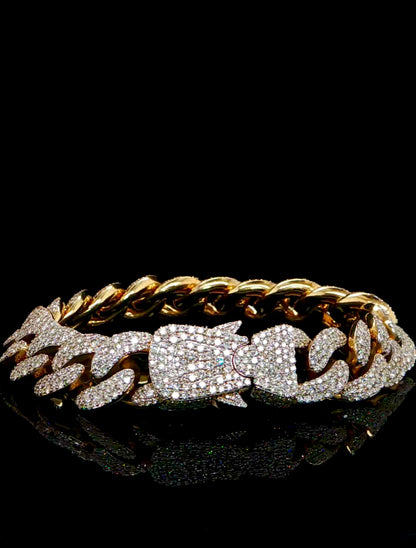 Gold chain bracelet with diamond accents on a black background