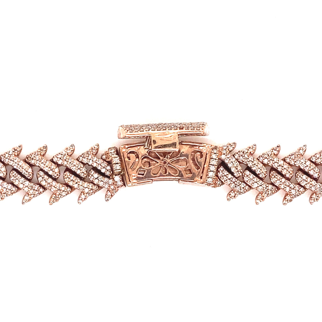 This diamond rose gold Cuban link is secured by a curved lock with a flower design at the center. 