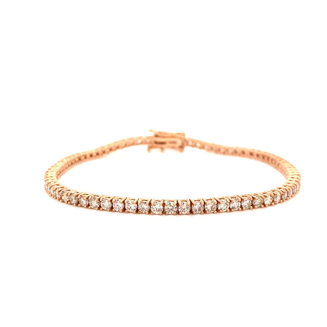 This tennis bracelet is handcrafted with 14 karats in rose gold and contains round cut VS clarity diamonds. 